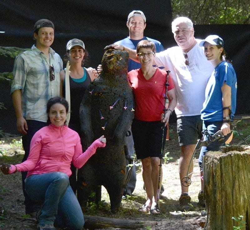 group posing with wooden bear