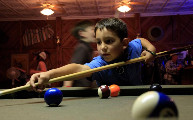 shooting-pool young boy shooting pool