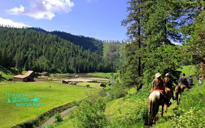 horseback group on trail overlooking the ranch