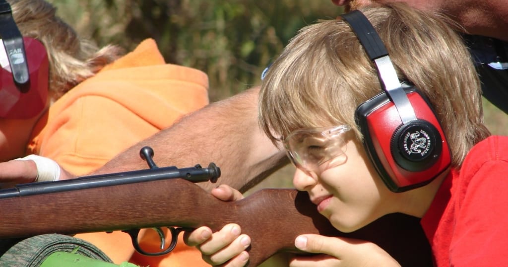 Young person aiming a rifle.