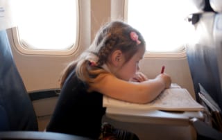 Young girl coloring while on an airplane