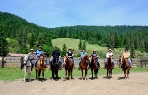 A family sits upon their steeds for a picture to commemorate their Idaho vacation.