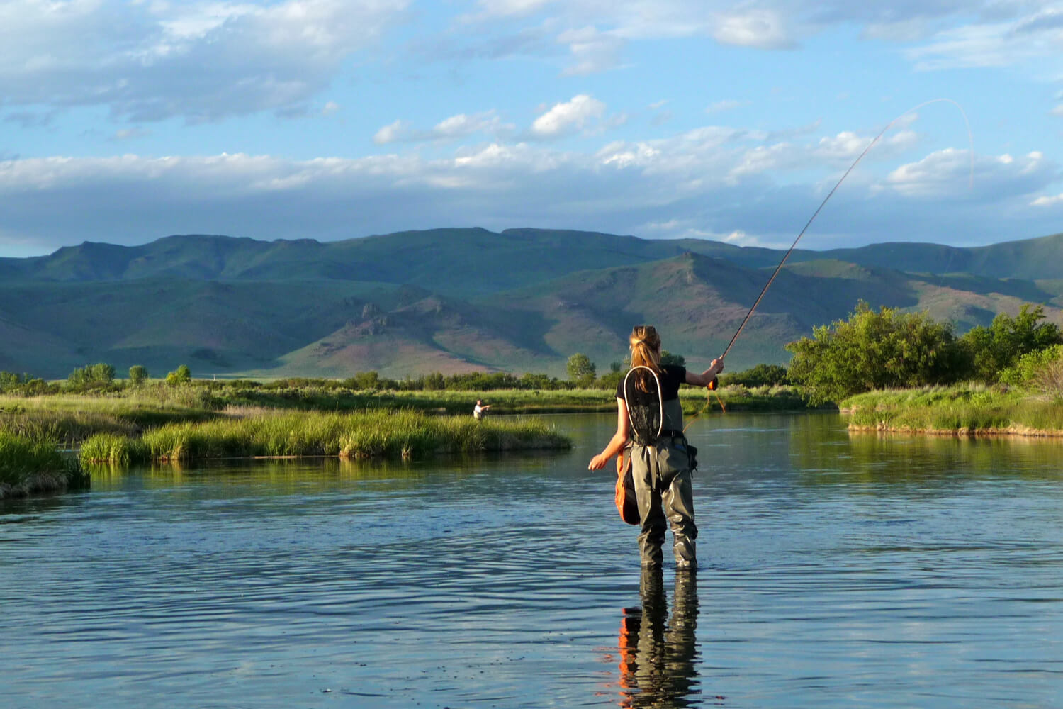 A solitary female angler tries her hand at fishing in Idaho on the Saint Joe River.