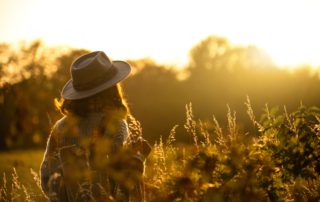 Fall in Idaho: A woman looks into the distance while walking through a mountain meadow in the Idaho Panhandle.